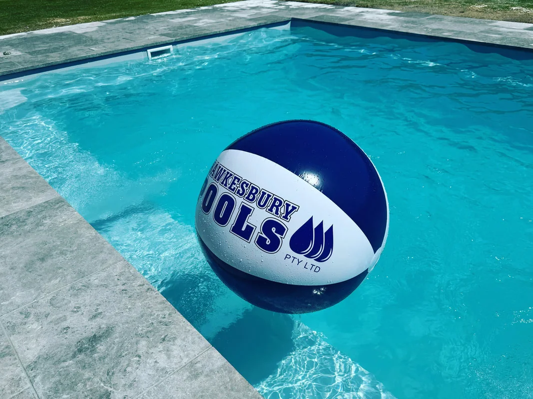 Hawkesbury Pools branded beach ball floating in a finished pool
